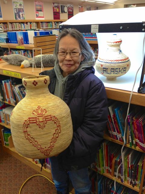 Chevak village elder Maggie Atcherian and her grandson Matt Atcherian display her native artwork for sale online.