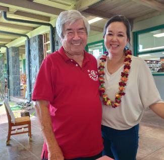 Two people smiling in a lobby with a chair in the background