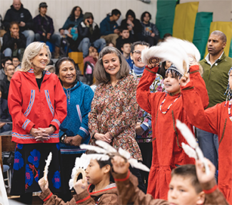 gathering of people watching children in costumes during a tribal dance