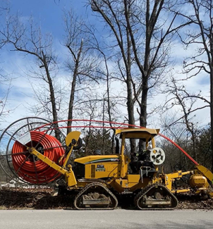 A tractor next to a few trees