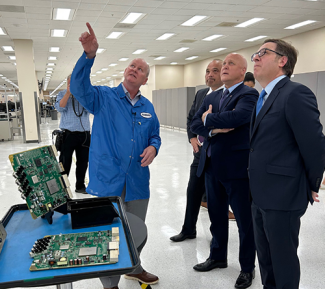 Technician doing a demonstration, pointing up at something and three people looking up too